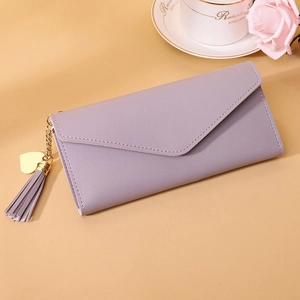 Detail of lavender purple long wallet with gold heart pendant and metal tassel on envelope flap