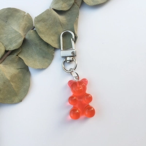 Detailed view of a translucent red resin gummy bear keychain on a white background
