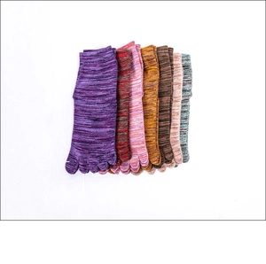 Stack of colorful knitted five-toe yoga socks in multiple vibrant vintage mixed colors