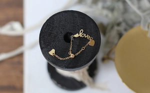 Detailed close-up of a 14K gold-plated adjustable chain ring with love and heart charms