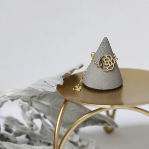 Detail of 14K gold plated camellia flower adjustable chain ring on a display stand