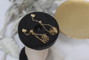 Close-up of 14K gold plated chain rings with Good Luck charm and camellia flower detail