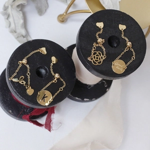 Detailed close-up of 14K gold plated chain rings with Good luck and rose pendants