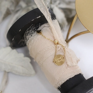 Detail of adjustable 14K gold-plated ring with Good luck engraving and camellia charm