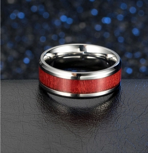 Polished titanium steel ring with inlaid red wood grain texture on black leather stand
