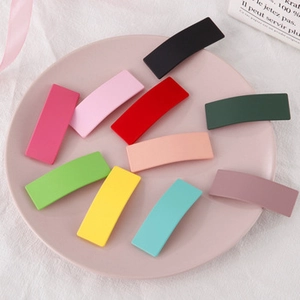 Detailed set of 10 matte rectangular hair clips in vibrant colors on a pink tray