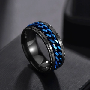 Macro shot of men's black spinner ring with blue chain inlay and polished steel texture