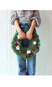 Detailed view of Christmas wreath with pine cones, cotton, berries and plaid bow
