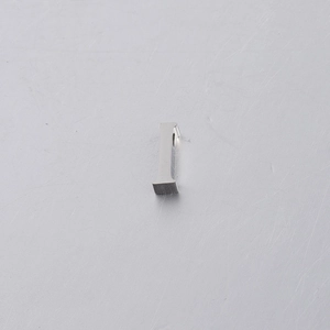 Macro shot of mirror-polished silver stainless steel number 1 bead charm on metal surface