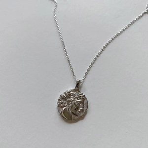 Detail of a 925 sterling silver coin necklace featuring a vintage embossed portrait