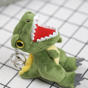 Close-up of green plush dinosaur keychain with soft texture and metal ring detail