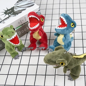 Detail of colorful plush dinosaur keychains in green, red, blue and dark green tones
