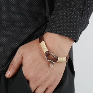 Handmade woven leather bracelet for men featuring a brown cord and silver horseshoe clasp