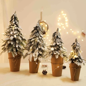 Set of 4 mini flocked Christmas trees with warm LED lights and rustic paper bases