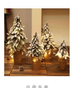 Mini snow-flocked Christmas trees in paper-wrapped pots with warm LED fairy lights