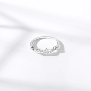 Macro view of silver leaf pattern ring with sparkling zircons and artistic shadows