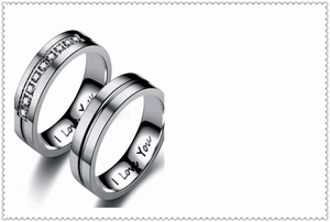 Close-up of titanium steel couple rings with I Love You engraving and sparkling crystal inlay