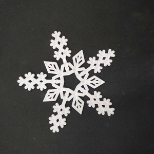 Detailed close-up of white snowflake-shaped plastic ornament for Christmas tree decor