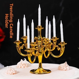 Golden 9-arm candelabra cake topper with white spiral candles on a cream base