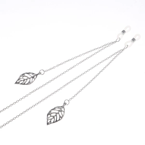 Detailed close-up of silver metal eyewear chain featuring intricate hollow leaf pendants