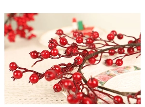 Gros plan de branches de baies rouges artificielles brillantes pour décoration de Noël