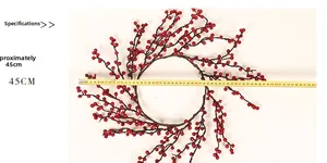 Vue détaillée de la couronne de Noël 45CM avec baies rouges et mesure avec un ruban jaune
