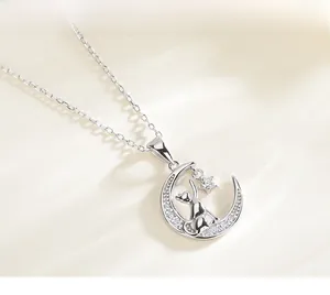 Macro shot of silver crescent moon and cat pendant with white zircon star detailing