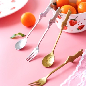 Close-up of golden and silver stainless steel spoons and forks with dog and bone motifs