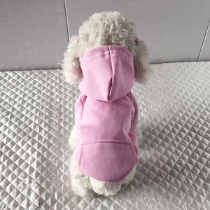 Rear view of a small white dog wearing a pink fleece pet hoodie with a functional pocket
