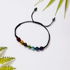 Detail of adjustable black braided cord bracelet with seven vibrant rainbow color beads