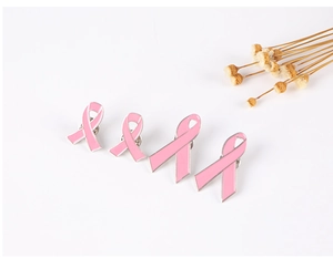 Detail view of four pink ribbon breast cancer awareness pins in different sizes