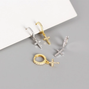 Macro shot of gold and silver S925 sterling silver cross earrings with paved zircons