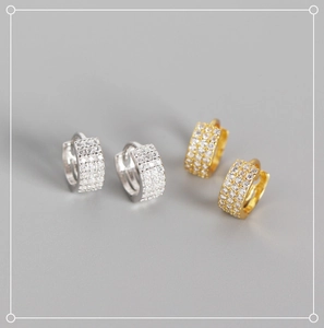 Macro detail of geometric triple-row pavé zircon hoop earrings in gold and silver