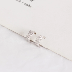 Detail shot of 925 sterling silver huggie earrings with triple-row pavé cubic zirconia