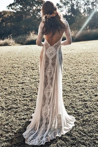 Detailed back view of white lace wedding dress with backless design and long train
