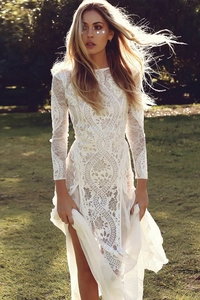 Detailed view of intricate floral lace crochet on a long-sleeved white evening gown