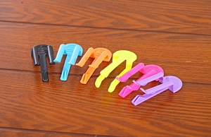 Colorful plastic anti-slip clips for trash cans neatly arranged on a wooden surface