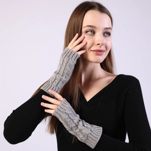 Macro detail of grey cable knit pattern on arm warmers with fingerless design