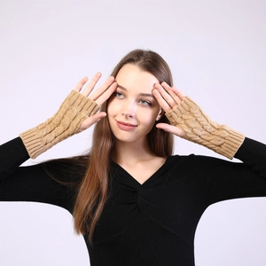 Detail shot of camel cable knit fingerless gloves showing warm textured arm sleeves