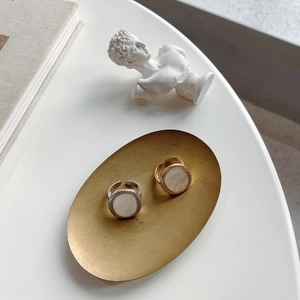 Detailed view of adjustable 925 silver shell rings on vintage gold tray display