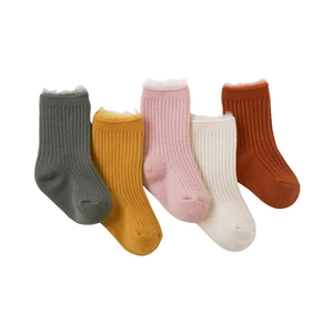 Five pairs of thick fleece-lined baby socks in neutral tones with white fuzzy cuffs