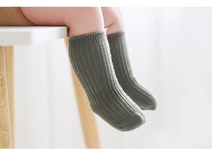 Close-up of thick ribbed knit baby socks in dark grey green for warmth and comfort