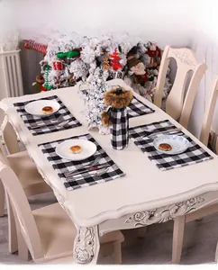 Detail of black and white buffalo plaid table mats and festive wine bottle cover décor
