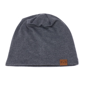 Close-up of a grey knit beanie featuring a brown leather patch with F&S branding