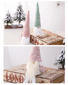Detail of pink and green plush Christmas gnomes with soft fabric hats and faux fur beards