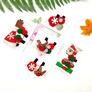 Close-up of Christmas hair clips with Santa, tree and snowflake patterns on a gift card
