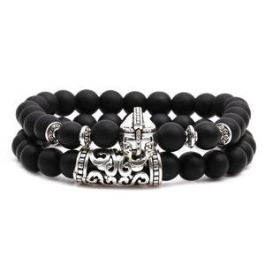 Matte black beaded bracelet set with silver Spartan helmet and engraved metal tube charms