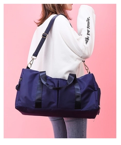 Detail of dark blue waterproof sports bag with shoe compartment and nylon straps on a model