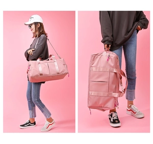 Detail of pink waterproof sports bag showing hand straps and adjustable shoulder strap