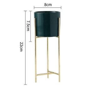 Dettaglio del vaso in ceramica verde scuro con supporto in oro e altezza totale di 22cm
